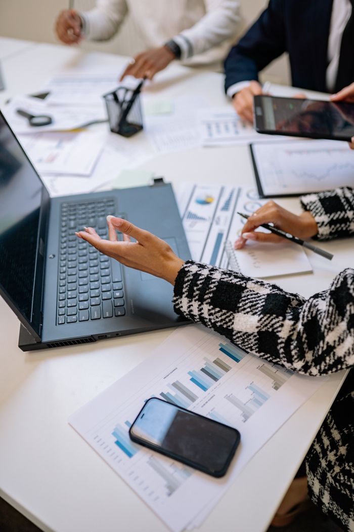 Mastering the First Impression: Your intriguing post title goes here Collaboration at an office meeting with laptops and reports on the table.
